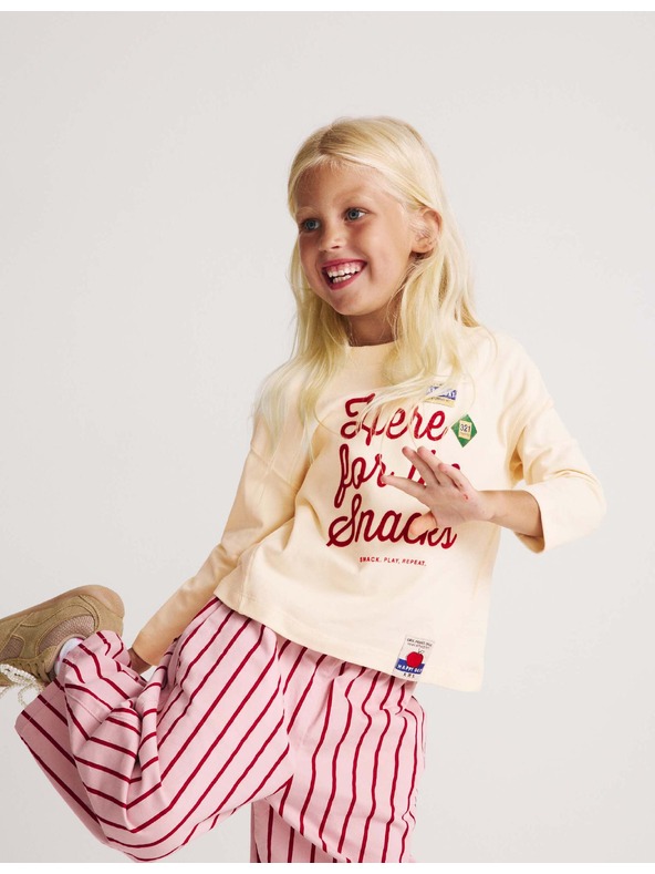 Marks & Spencer Top z čisté bavlny s nápisem „For The Snacks“ (2–8 let) Marks & Spencer smetanová